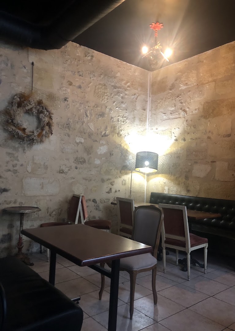 Une salle en pierre avec tables de café et chaises anciennes