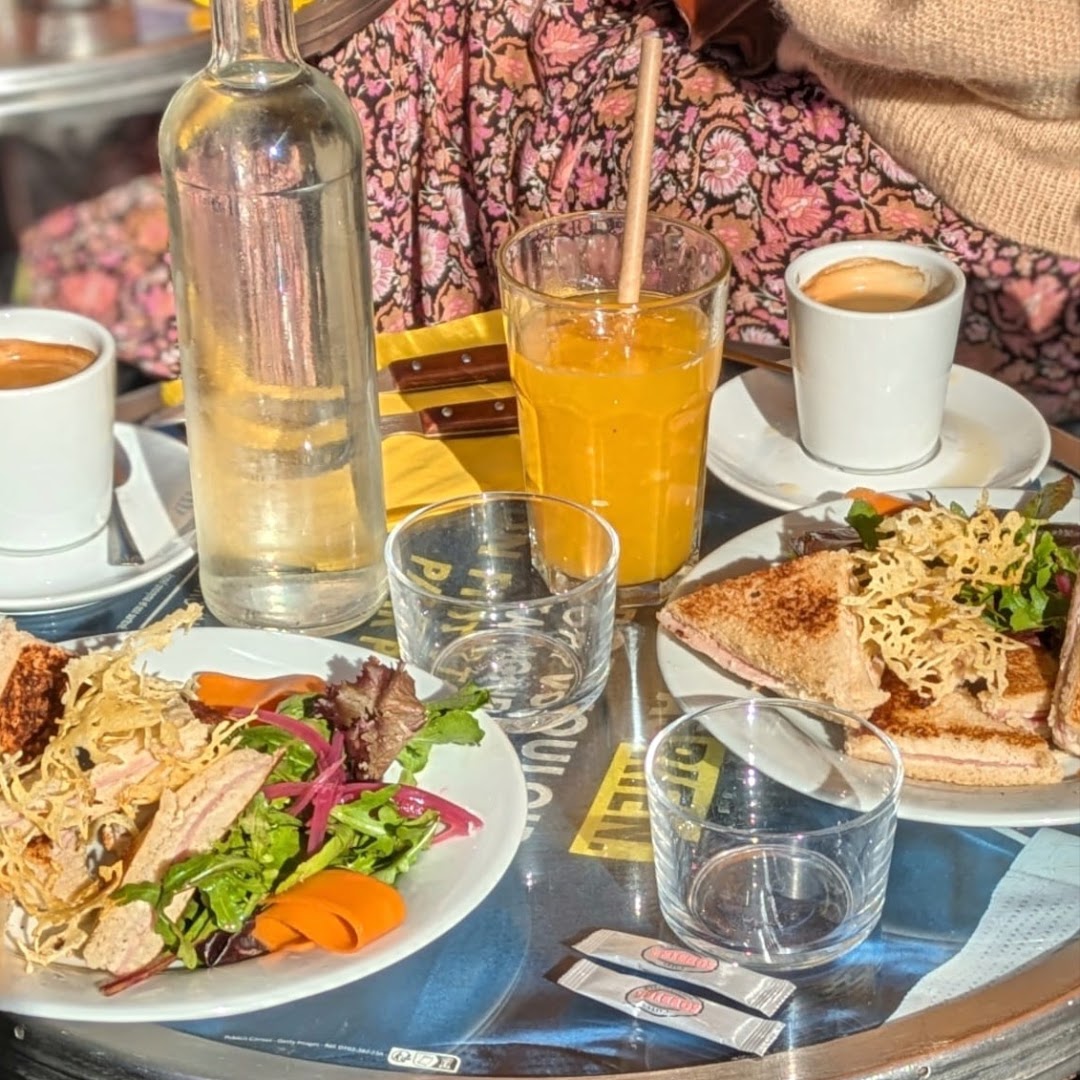 Deux assiettes de sandwiches grillés avec cafés et jus d’orange
