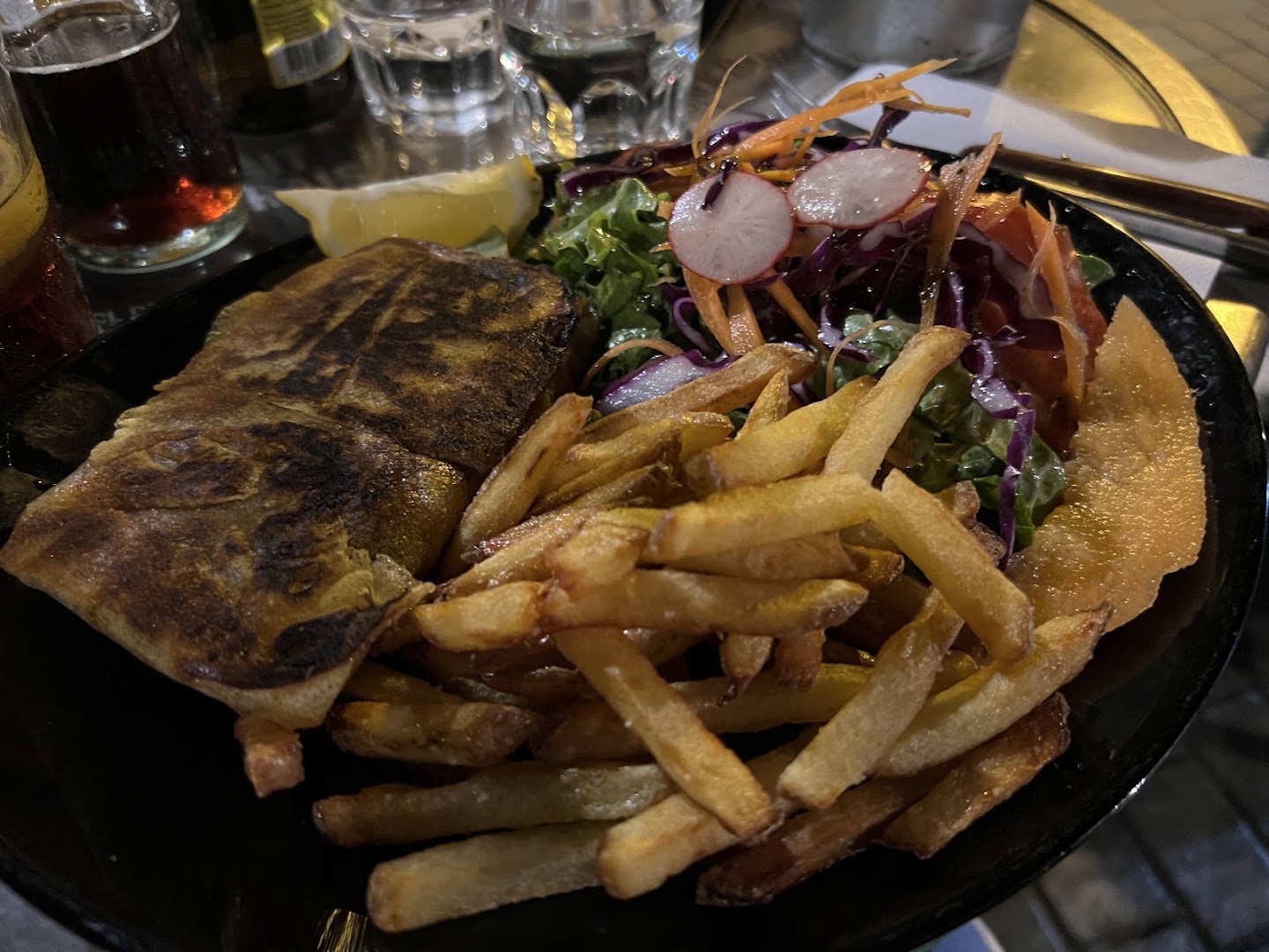 Un poisson grillé avec frites et salade